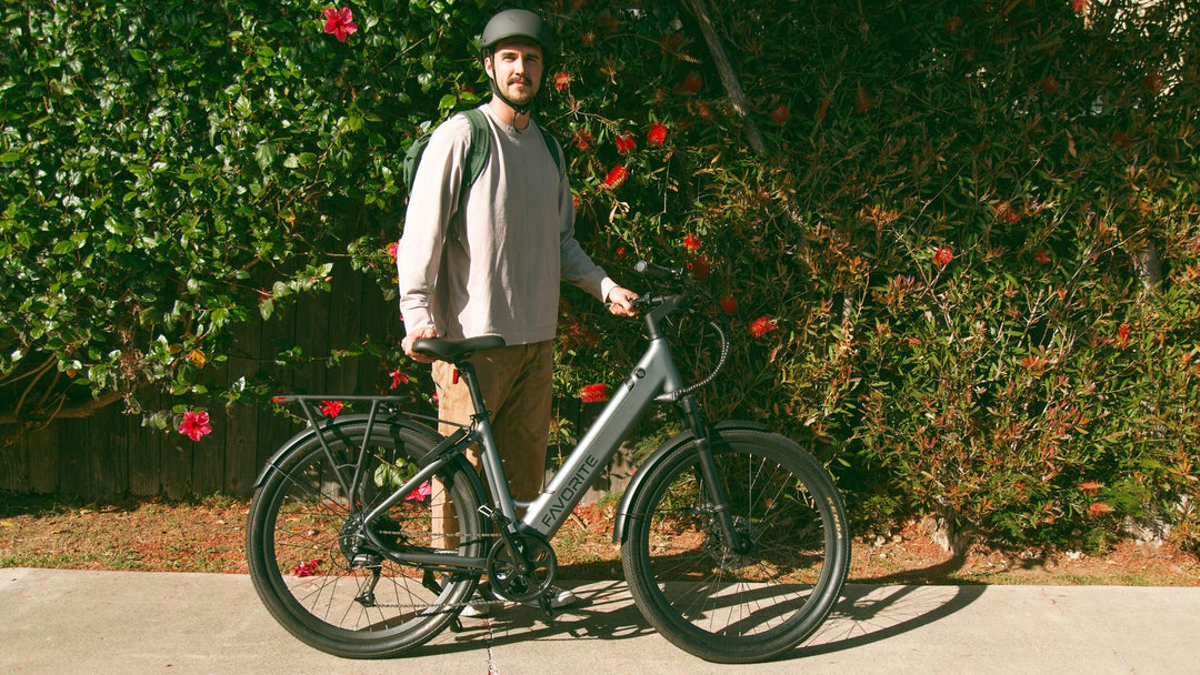 FavoriteBikes rider in everyday commuting clothes with backpack beside an e-bike.