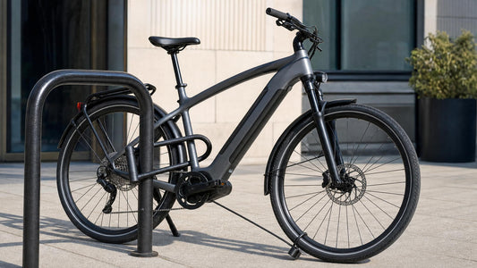 Modern electric bike securely locked with a heavy U-lock to a steel bike rack on a sunny city sidewalk, with a secondary cable through the front wheel