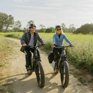 Couple riding Favoritebikes StormX Fat tire Ebike Costco on a dirt trail, demonstrating comfort and performance in outdoor cycling.