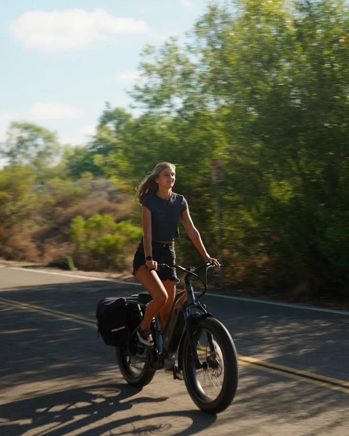 A rider enjoying a FavoriteBikes e-bike on a sunlit road
